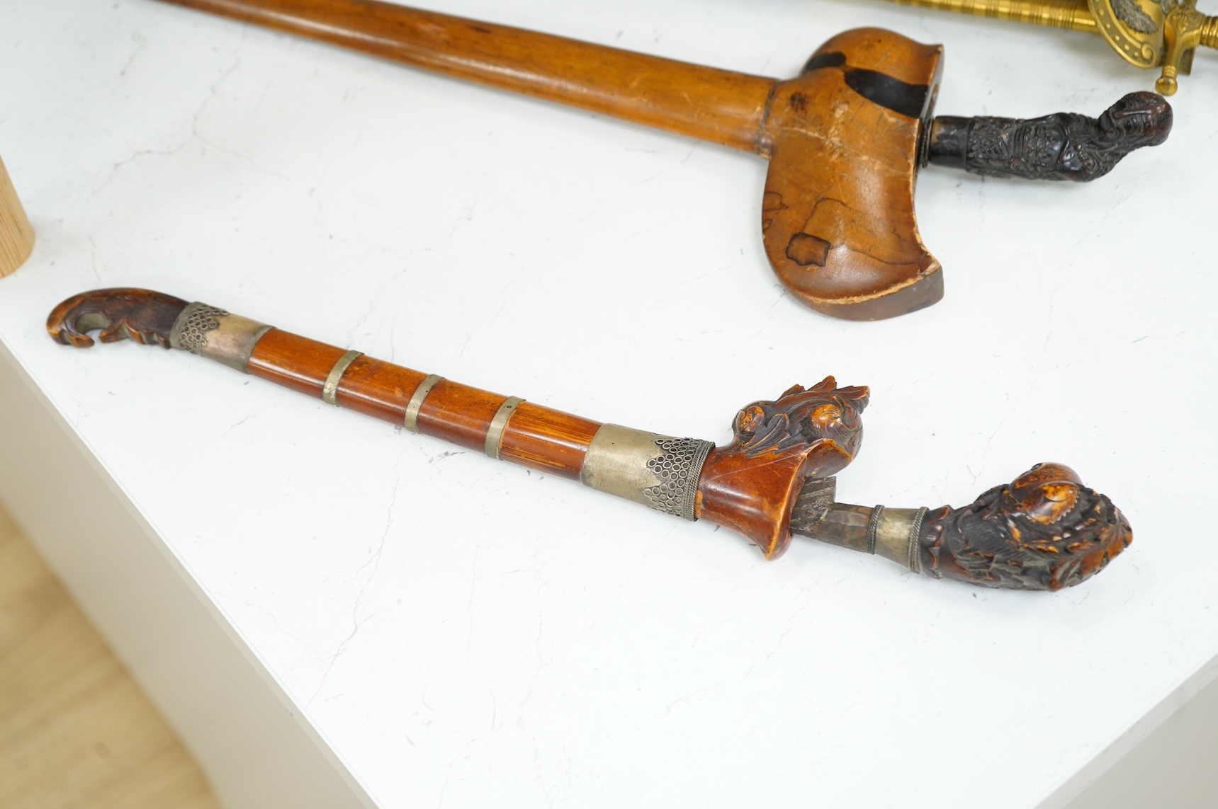 A Javanese dagger kris with straight pamor blade, wooden hilt carved as raksha, in its wooden sheath, together with a decorative dagger bade-bade, with etched blade